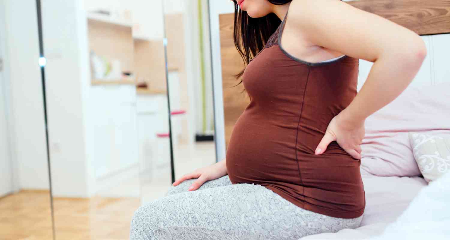 Pourquoi a-t-on mal au dos en début de grossesse : causes et solutions